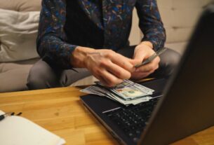 momak broji novac i koristi laptop