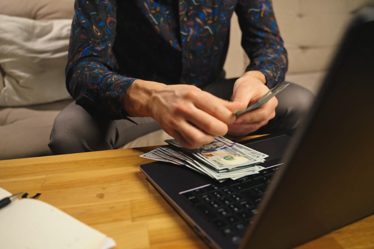 momak broji novac i koristi laptop