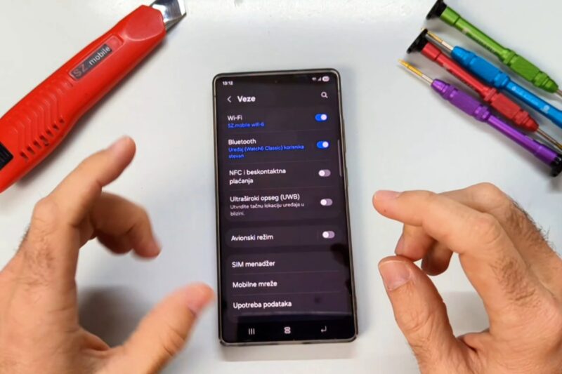 osoba podešava bateriju na telefonu