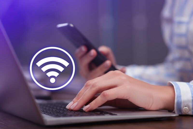 prikaz wifi mreže i osobe koja koristi laptop i telefon