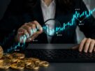 Investitorka analizira rast kriptovaluta na grafikonu pored Bitcoin i altcoin novčića