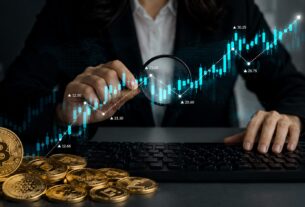 Investitorka analizira rast kriptovaluta na grafikonu pored Bitcoin i altcoin novčića